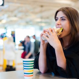 A young woman eating a sandwich in the airport