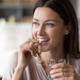 young woman taking supplement pill