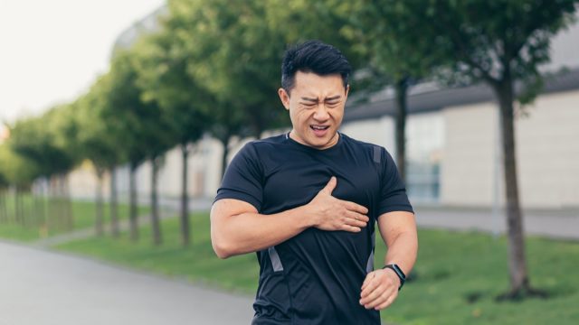 Fit young asian man having chest pain or stroke