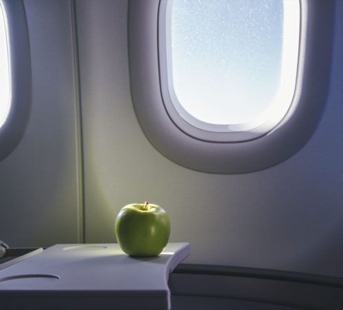 Apple on tray table of plane