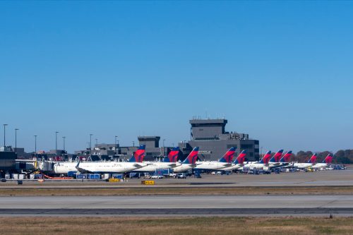 Delta jet airplanes lined up at terminal and being serviced between flights at Hartsfield-Jackson Atlanta International Airport.