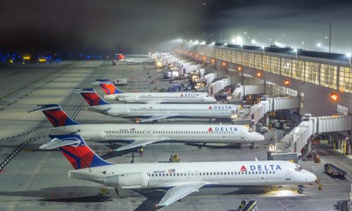 Several Delta Air Lines B717 airplanes at DTW airport, in a foggy night