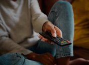 Woman hand holding television remote at home