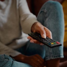 Woman hand holding television remote at home