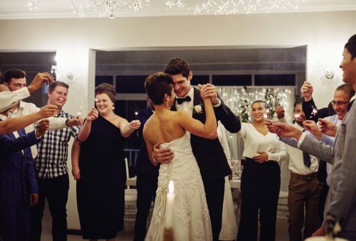 Shot of a young couple dancing at their wedding reception while surrounded by their friends and sparklers