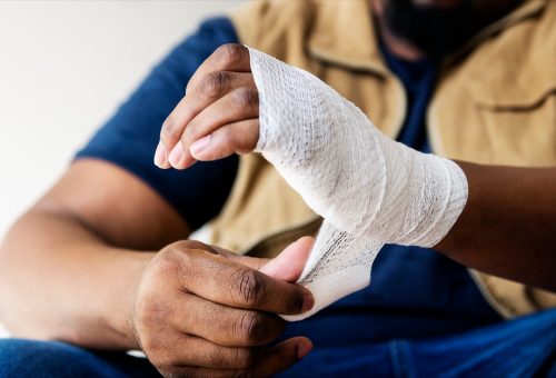 man wrapping an injured hand