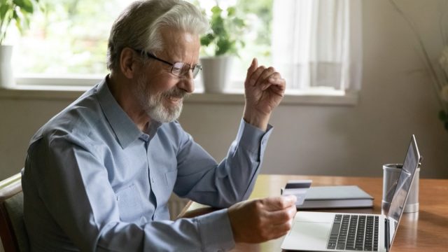 older man shopping online with credit card