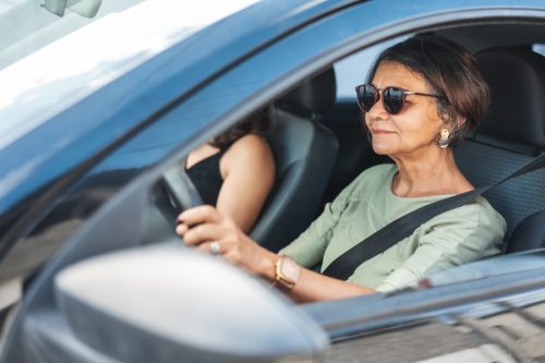 ผู้หญิงที่เป็นผู้ใหญ่ที่มีความสุขขับรถ