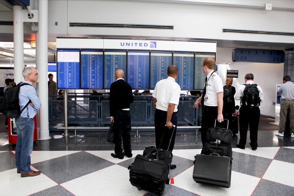 Những người đàn ông tại Sân bay Quốc tế O'Hare của Chicago đọc danh sách các chuyến khởi hành của United Airlines.  O'Hare là một trong những sân bay bận rộn nhất trên thế giới.