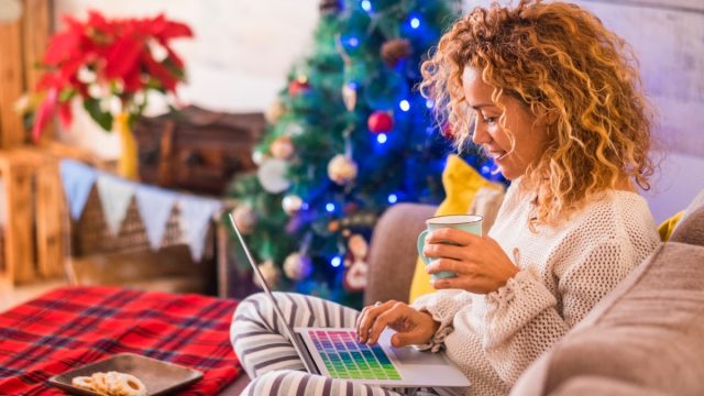 middle-aged woman checking email in front of christmas tree