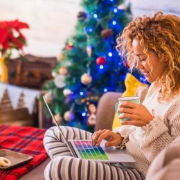 middle-aged woman checking email in front of christmas tree