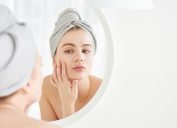 Woman looking at her skin in the mirror