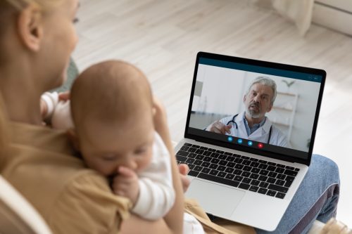 Young mother talking to doctor on computer