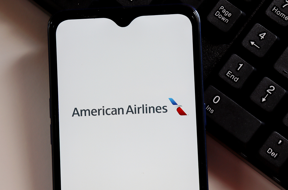The American Airlines logo on a smartphone screen sitting next to a keyboard
