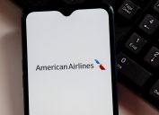 The American Airlines logo on a smartphone screen sitting next to a keyboard