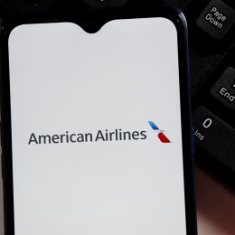 The American Airlines logo on a smartphone screen sitting next to a keyboard