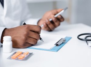 doctor making pills prescription online, using mobile phone, filling medical chart