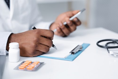 doctor making pills prescription online, using mobile phone, filling medical chart