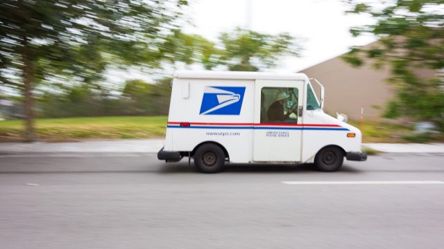 United States Post Office mail truck (USPS) speeding in Miami, Florida - motion blur panning.