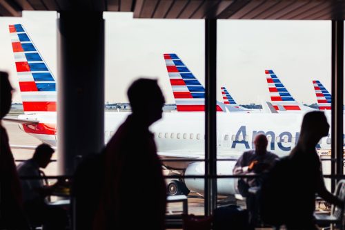 Chicago, IL, USA - July 17, 2017: American Airlines fleet of airplanes with passengers at O'Hare Airport passing through corridor.