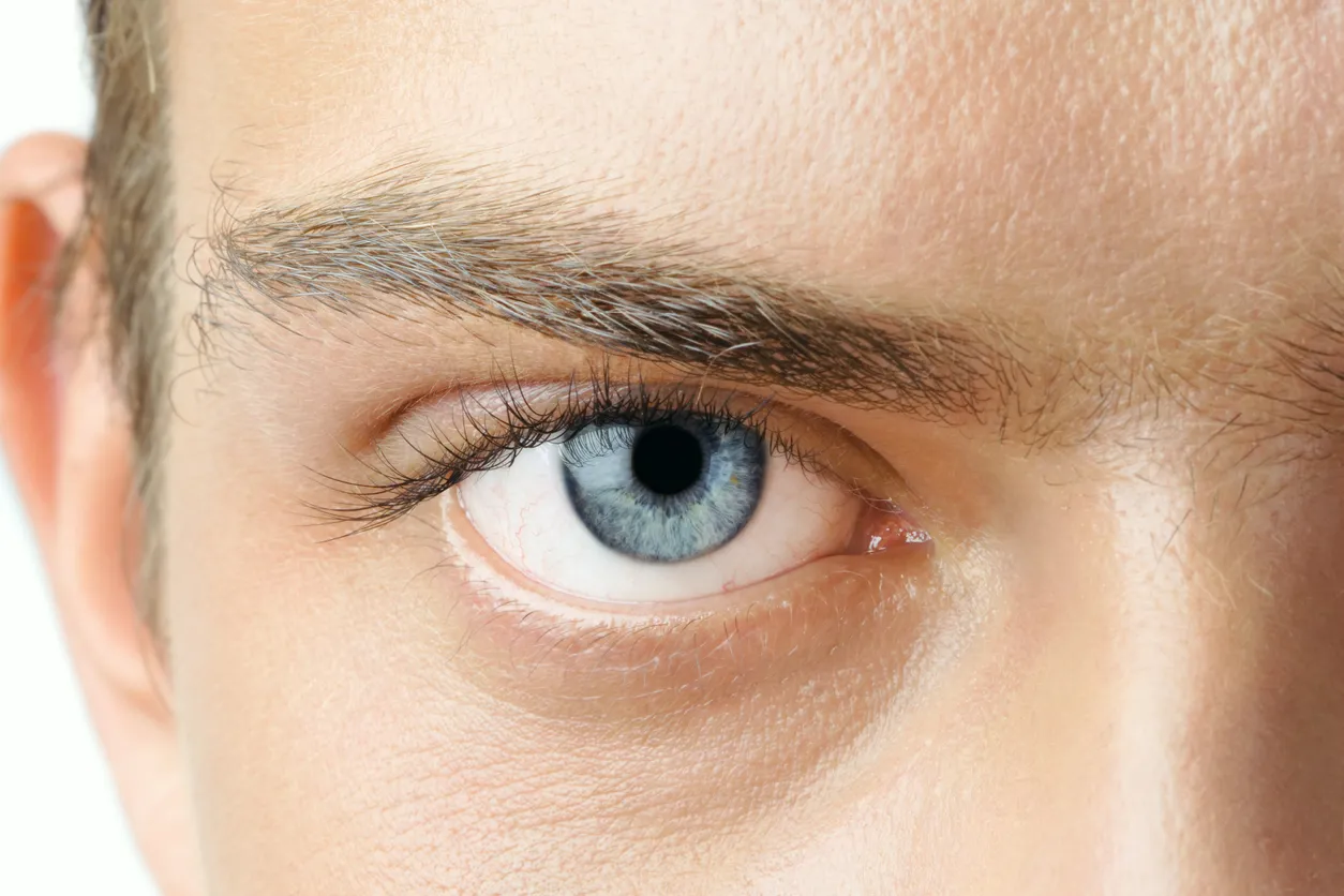 A close up of a man's blue eye