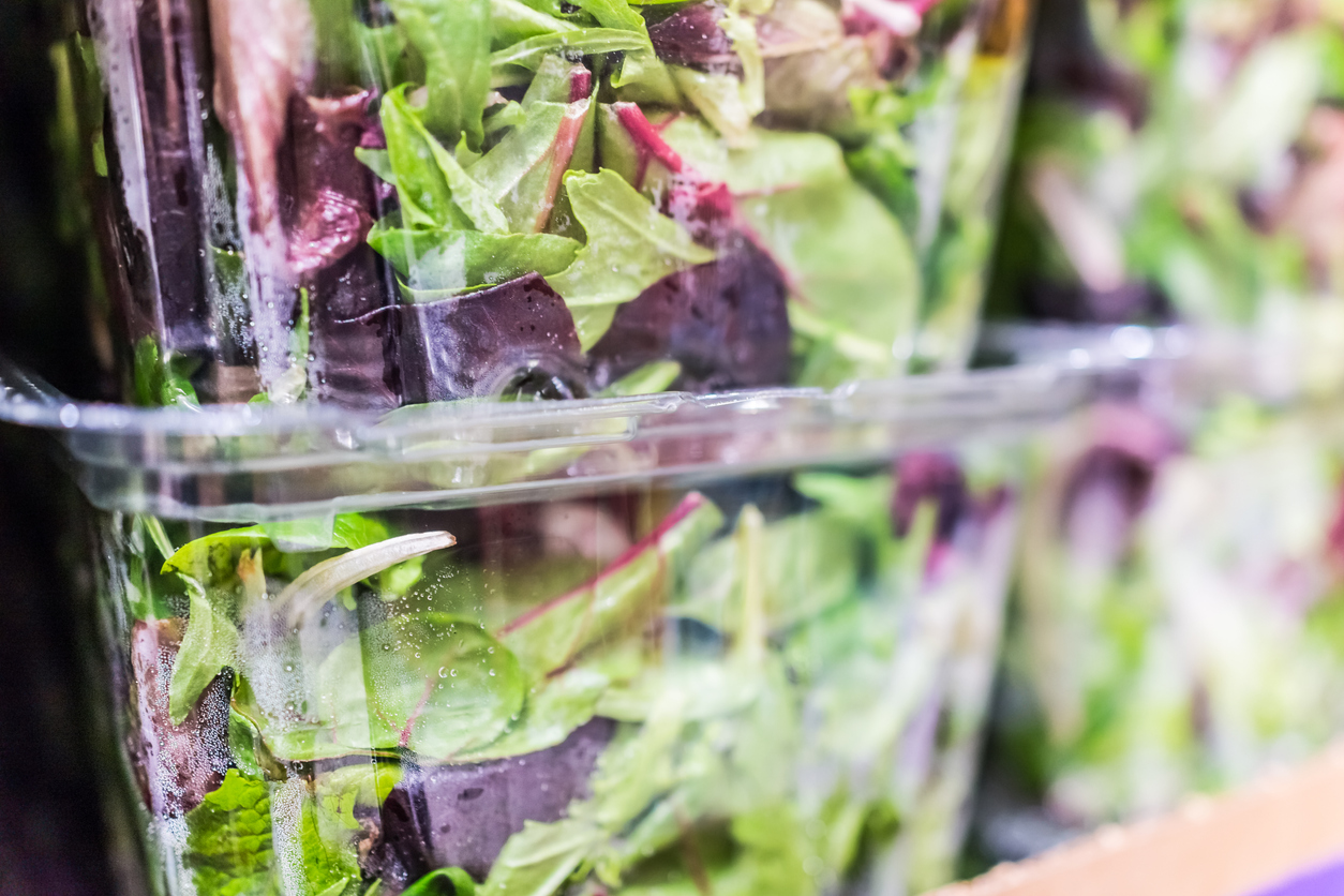 Packaged of pre-washed mixed greens on display in the supermarket