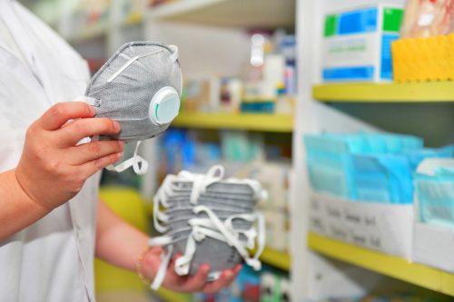 Pharmacist hand holding N95 mask in pharmacy drugstore