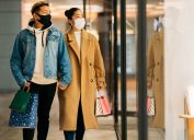 couple is shopping in the city while wearing protective face masks for illness prevention in winter.