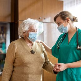 A nurse helps a senior woman around her home