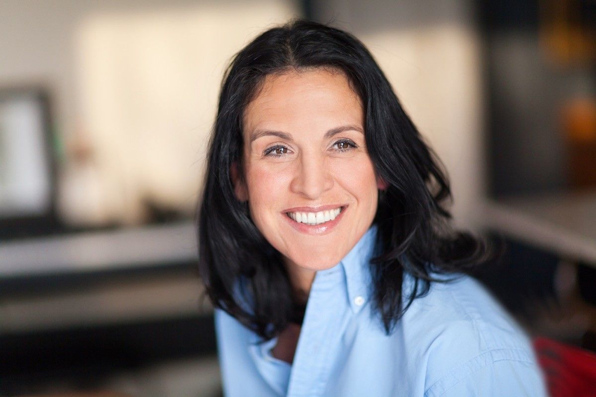 older professional woman with brown hair smiling