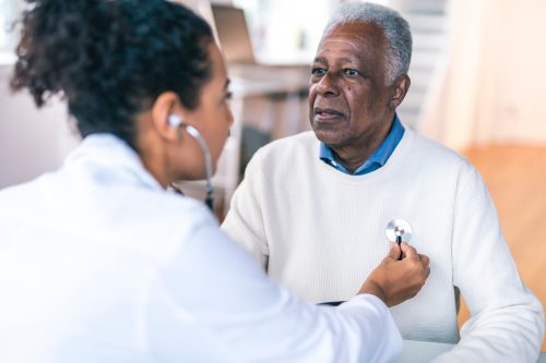 Doctor care ascultă bătăile inimii unui bătrân cu un stetoscop