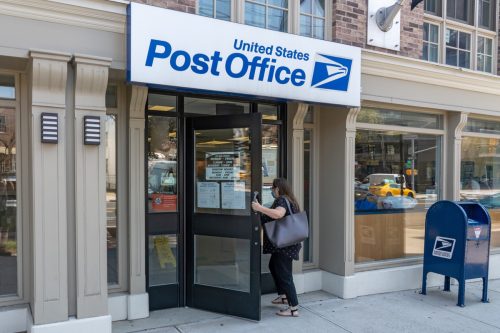 A woman enters a United States Postal Service (USPS) post office in Long Island City on August 17, 2020 in Queens Borough of New York City.
