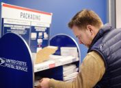 Mature man at the post office chooses an packaging - envelope or box for mailing. Postal system of the United States