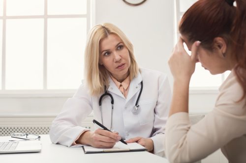 Femeie vorbind cu un medic
