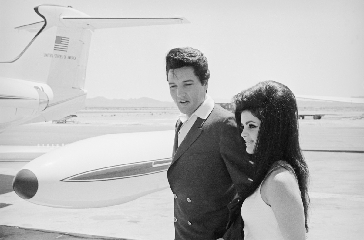 Elvis and Priscilla Presley in front of plane