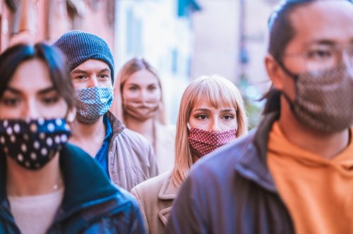 Friends group walking together wearing face mask at city center -