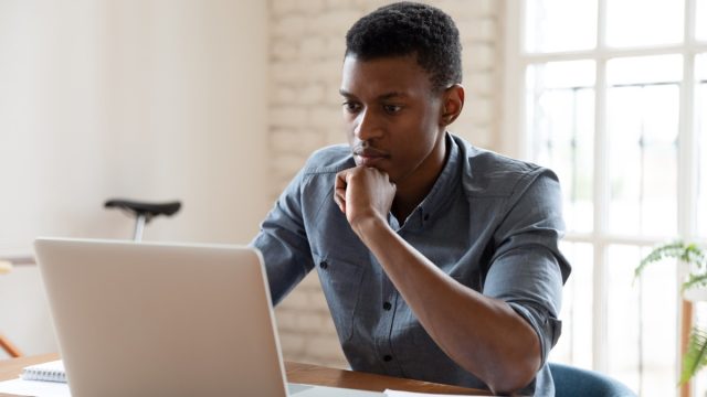 worker sit in front of laptop reading e-mail
