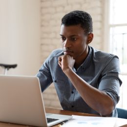 worker sit in front of laptop reading e-mail