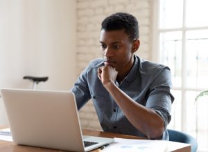 worker sit in front of laptop reading e-mail