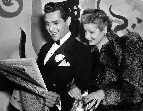 Desi Arnaz and Lucille Ball looking at a newspaper in 1941