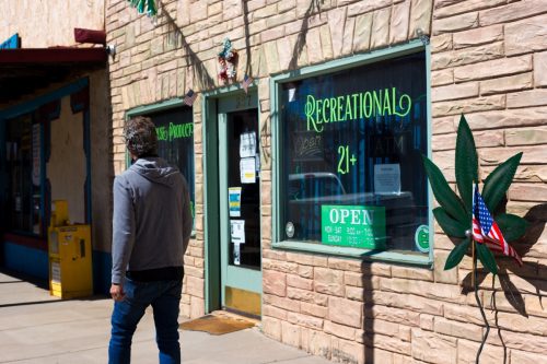 A man walks past a cannabis store in San Luis, CO, a town in the San Luis Vally in southern Colorado.