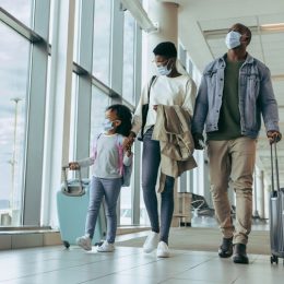 A family boarding a flight with their carry on luggage
