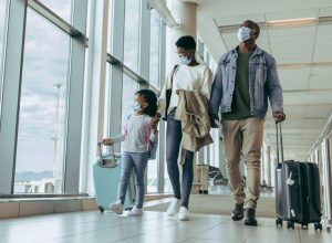 A family boarding a flight with their carry on luggage