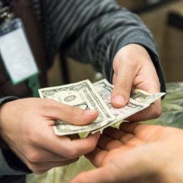 Woman giving cash when paying at a supermarket