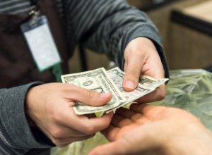 Woman giving cash when paying at a supermarket
