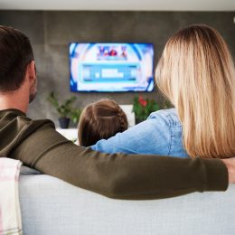 A family sitting on a couch while watching a streaming TV service