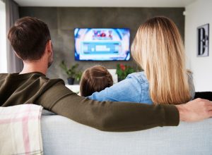 A family sitting on a couch while watching a streaming TV service