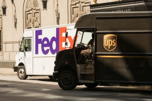 UPS und FedEx Lieferwagen nebeneinander auf der Straße