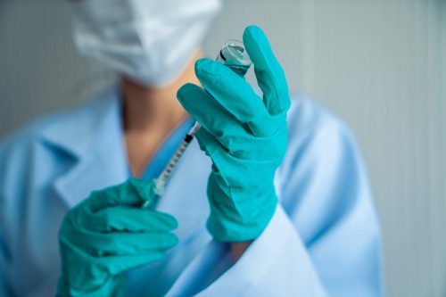 Un medic priceput pregătește cu pricepere vaccinul înainte de injectare.  Conceptul serviciului centru de vaccinare împotriva virusului Corona Covid 19.