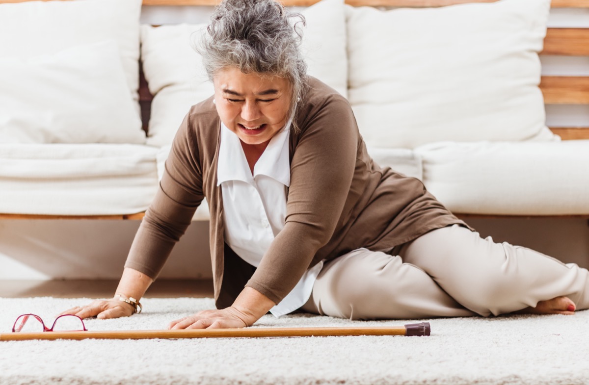 senior woman falling down lying on floor at home alone.